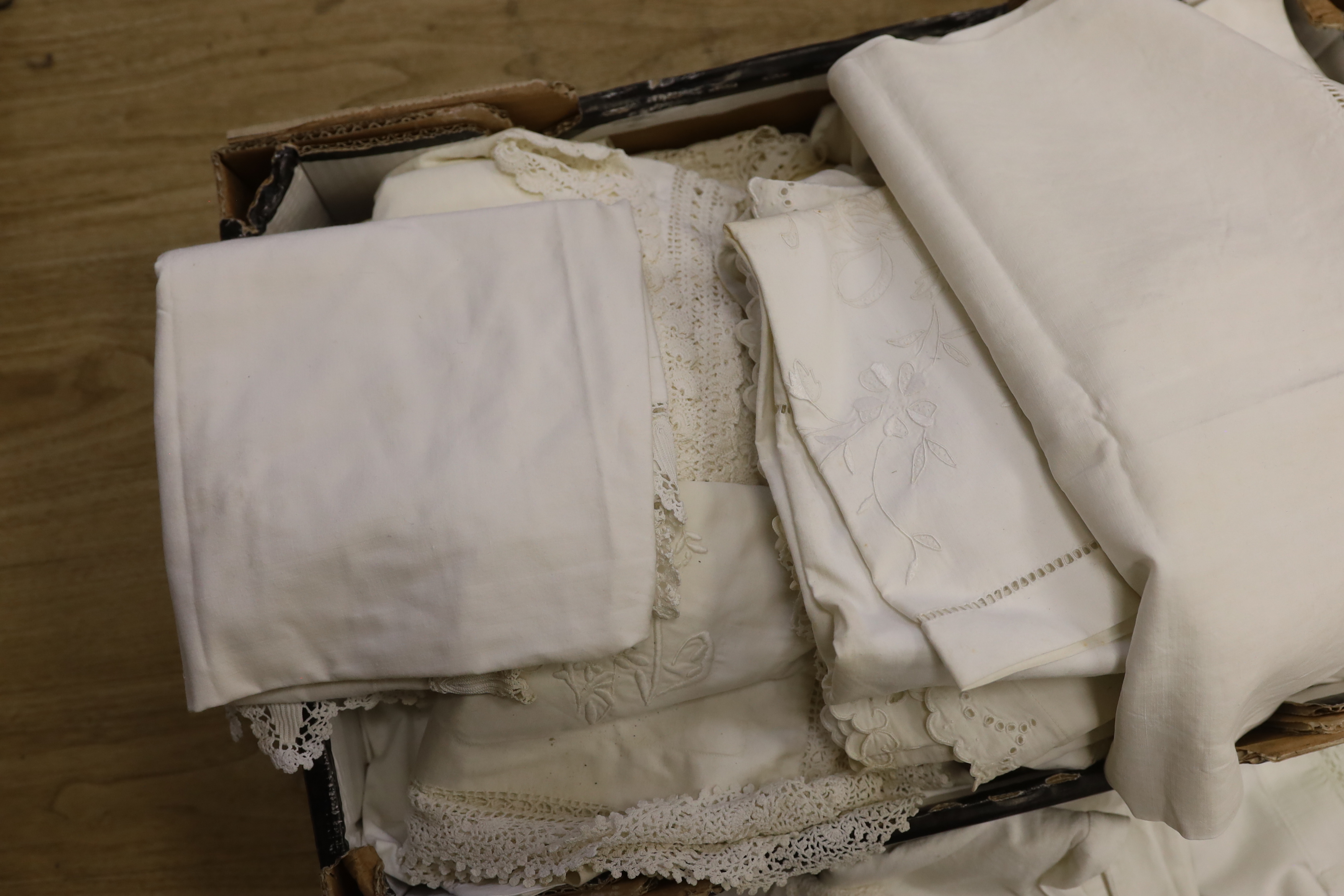 A large collection of French embroidered and crochet edged pillowcases and bolsters, some in pairs
